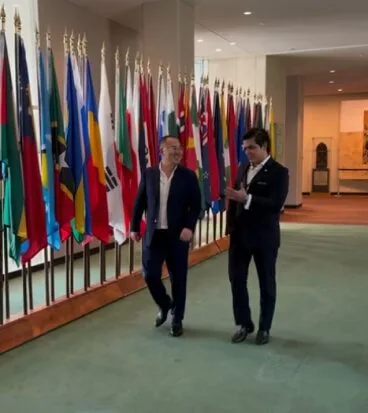 Frank Song walking a corridor of flags at the United Nations